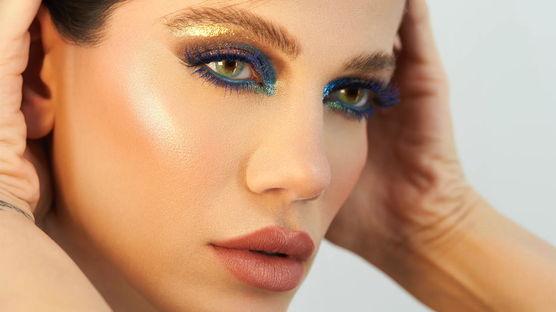 Close-up beauty look with blue and gold eye makeup